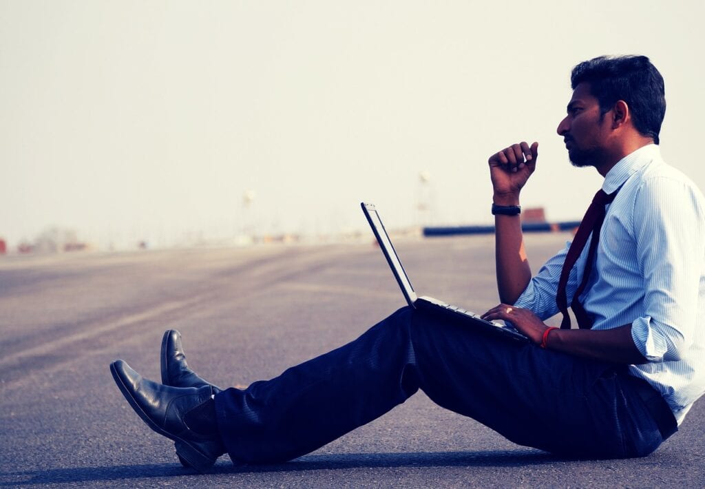 Man sitting on ground with laptop